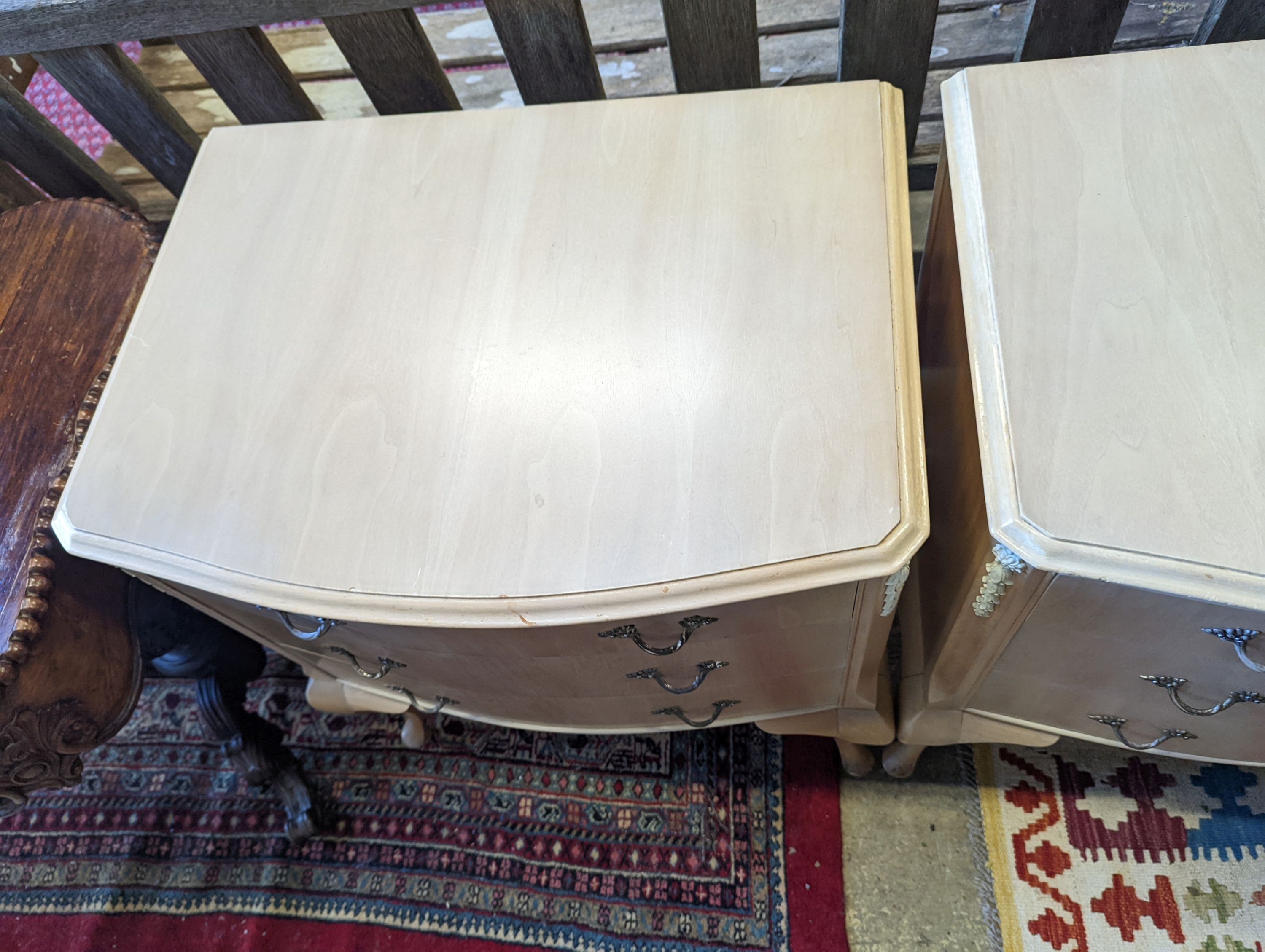 A pair of pale walnut three drawer bedside chests, width 60cm, depth 45cm, height 74cm